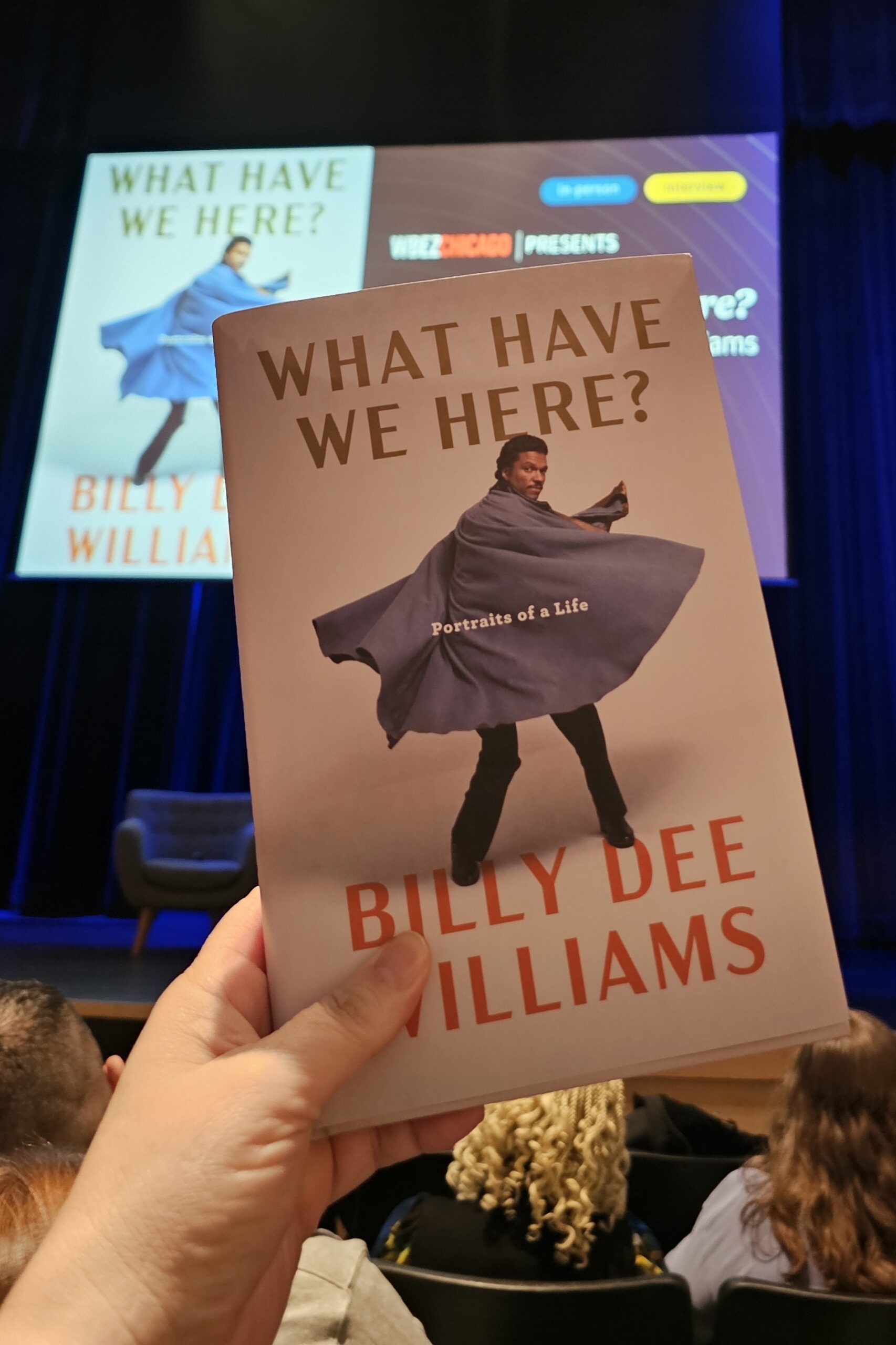 Billy Dee Williams book held in front of screen presentation