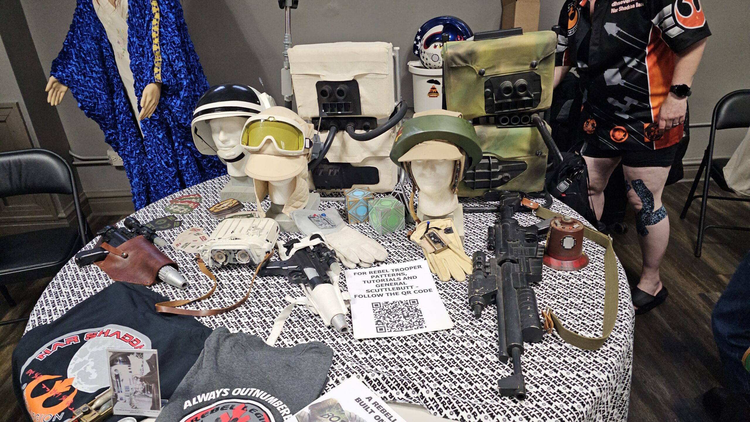 Helmets, t-shirts and blaster on table